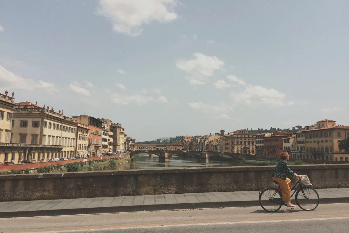 A cyclist on the embankment along the Arno