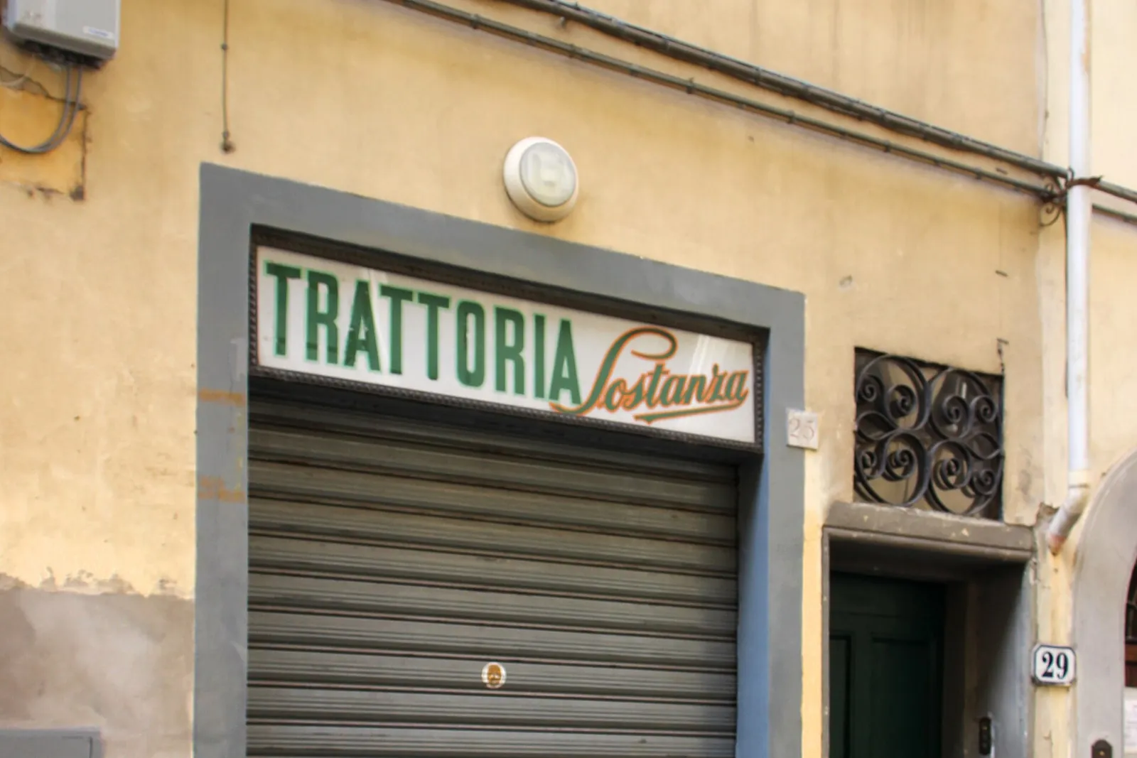 The shopfront of Trattoria Sostanza on Via del Porcellana, with its shutter down
